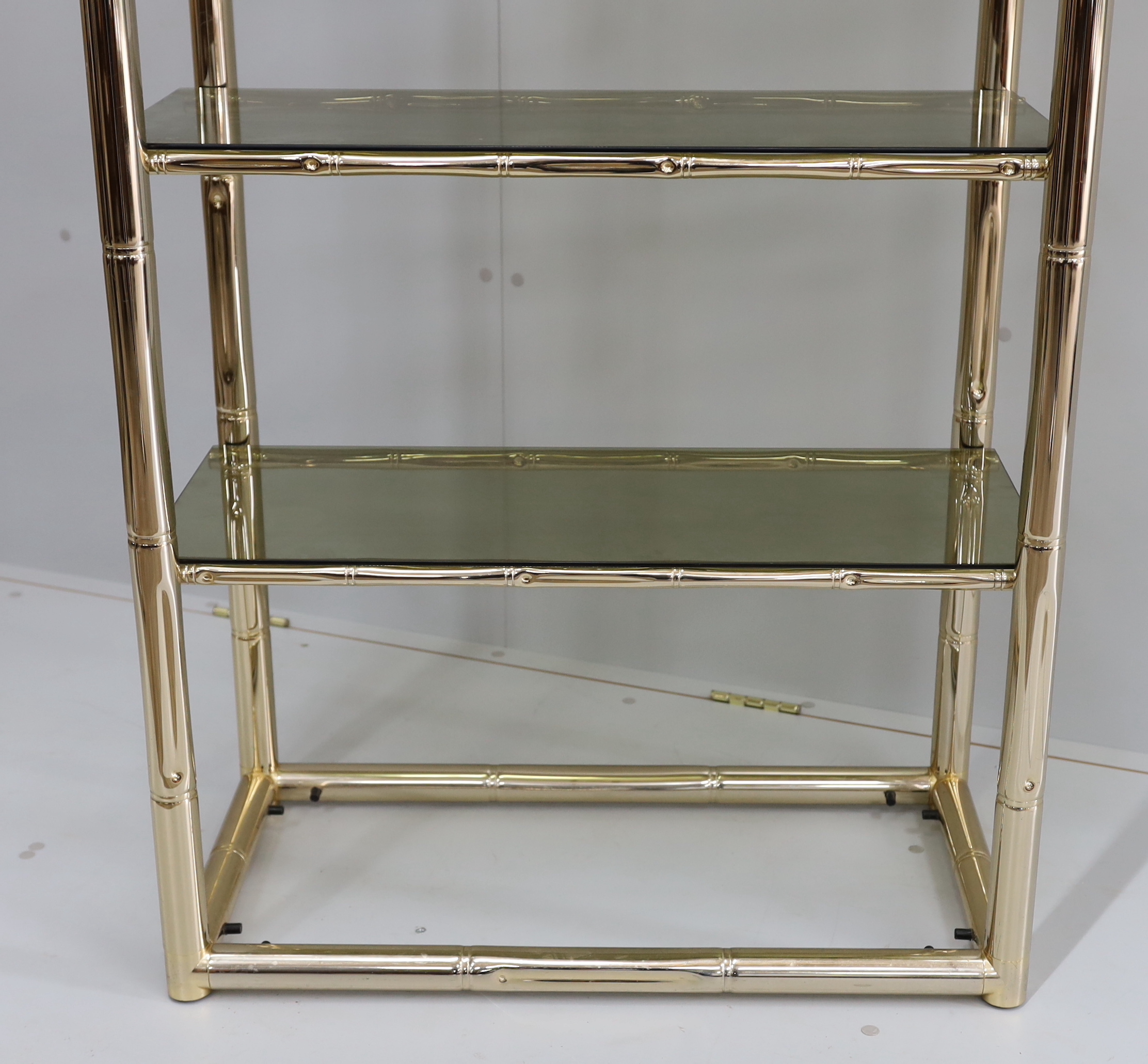 A Maison Jansen style faux bamboo brass and smoked glass five tier shelf unit, width 76cm, depth 39cm, height 180cm